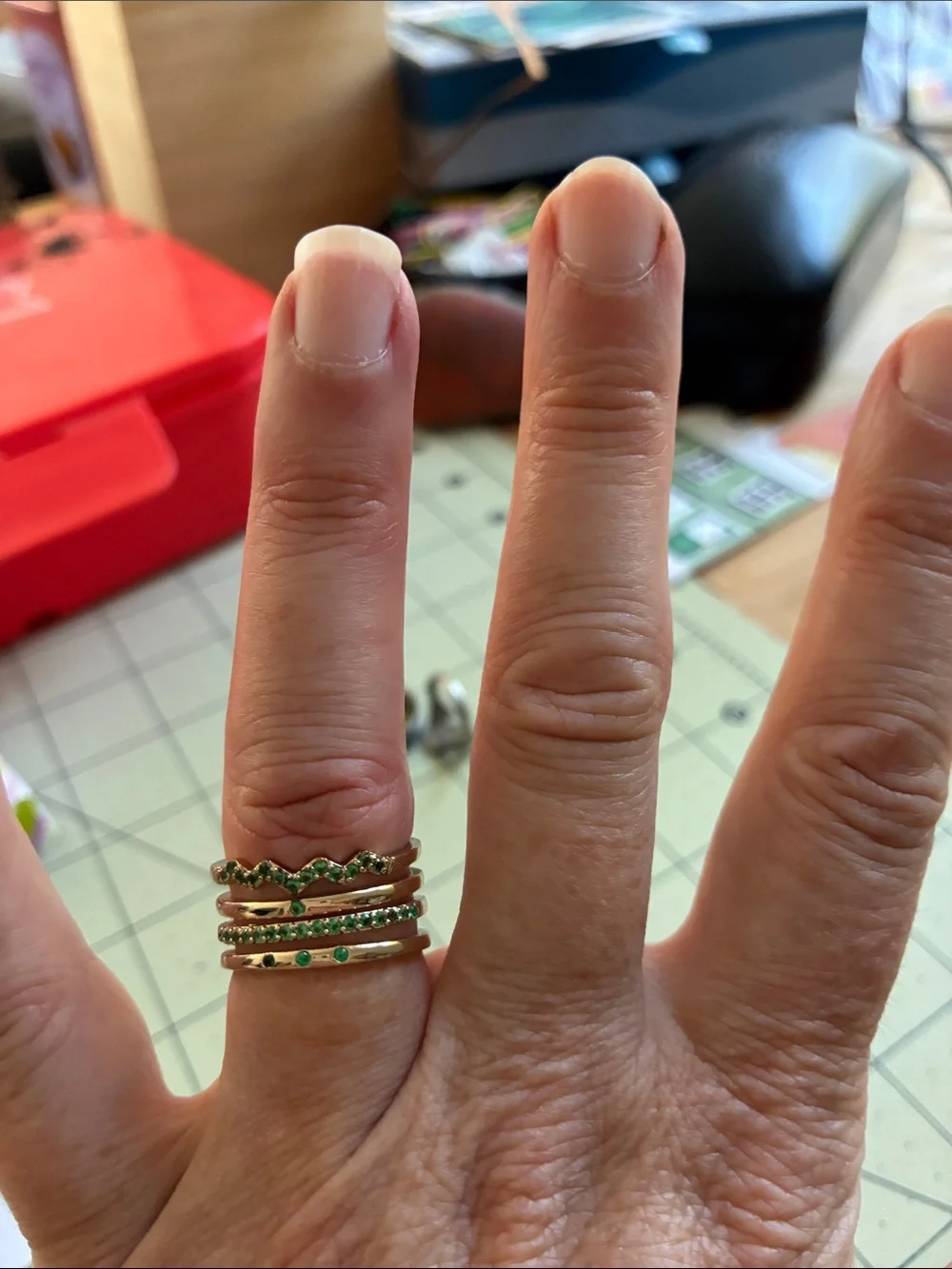 Gold tone ring with green stones. Adjustable size.